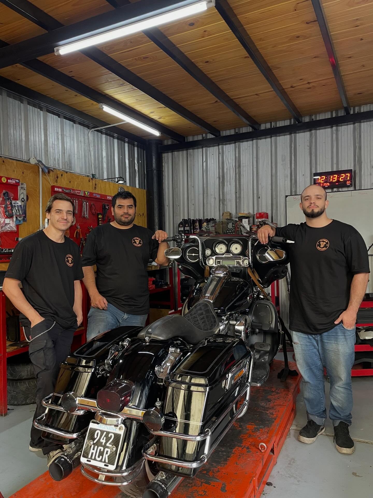 El equipo de V-Twin Motors junto a una moto en el taller